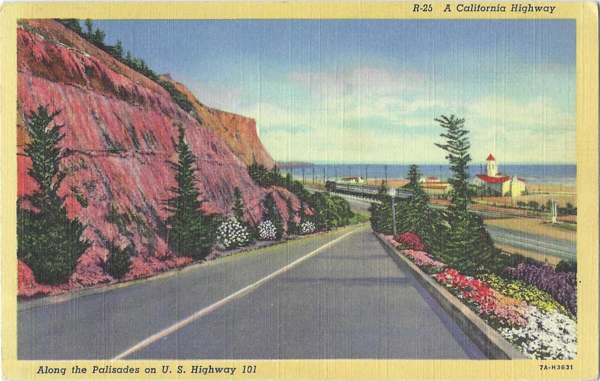 A descending road next to cliffs on the left and the Pacific Ocean on the right