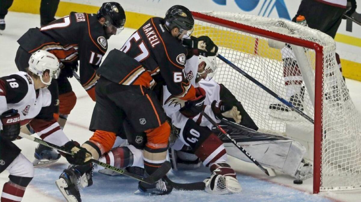 Ducks forward Rickard Rakell pushes the puck past a crowd, including goalie goalie Justin Peters for his second goal against Arizona on Nov. 4.