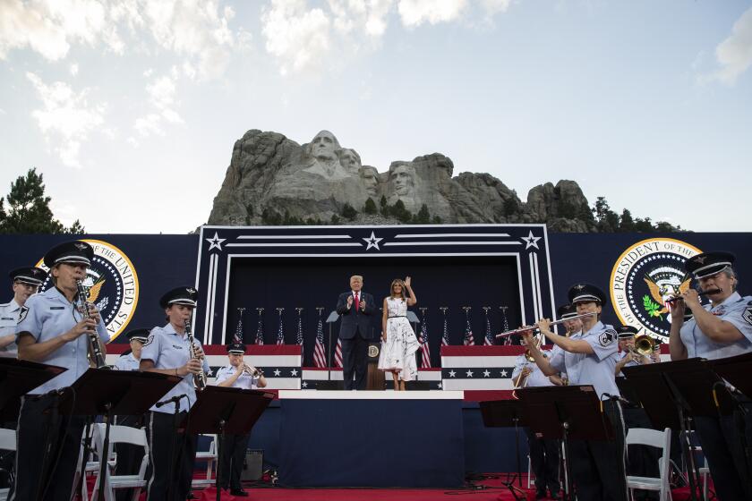 President Donald Trump, accompanied by first lady Melania Trump, stand during a ceremony at Mount Rushmore National Memorial, Friday, July 3, 2020, near Keystone, S.D. (AP Photo/Alex Brandon)