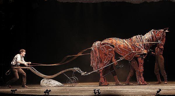 Andrew Veenstra is forced to teach the horse how to plow a field in the Tony-winning play "War Horse" at the Ahmanson Theatre.