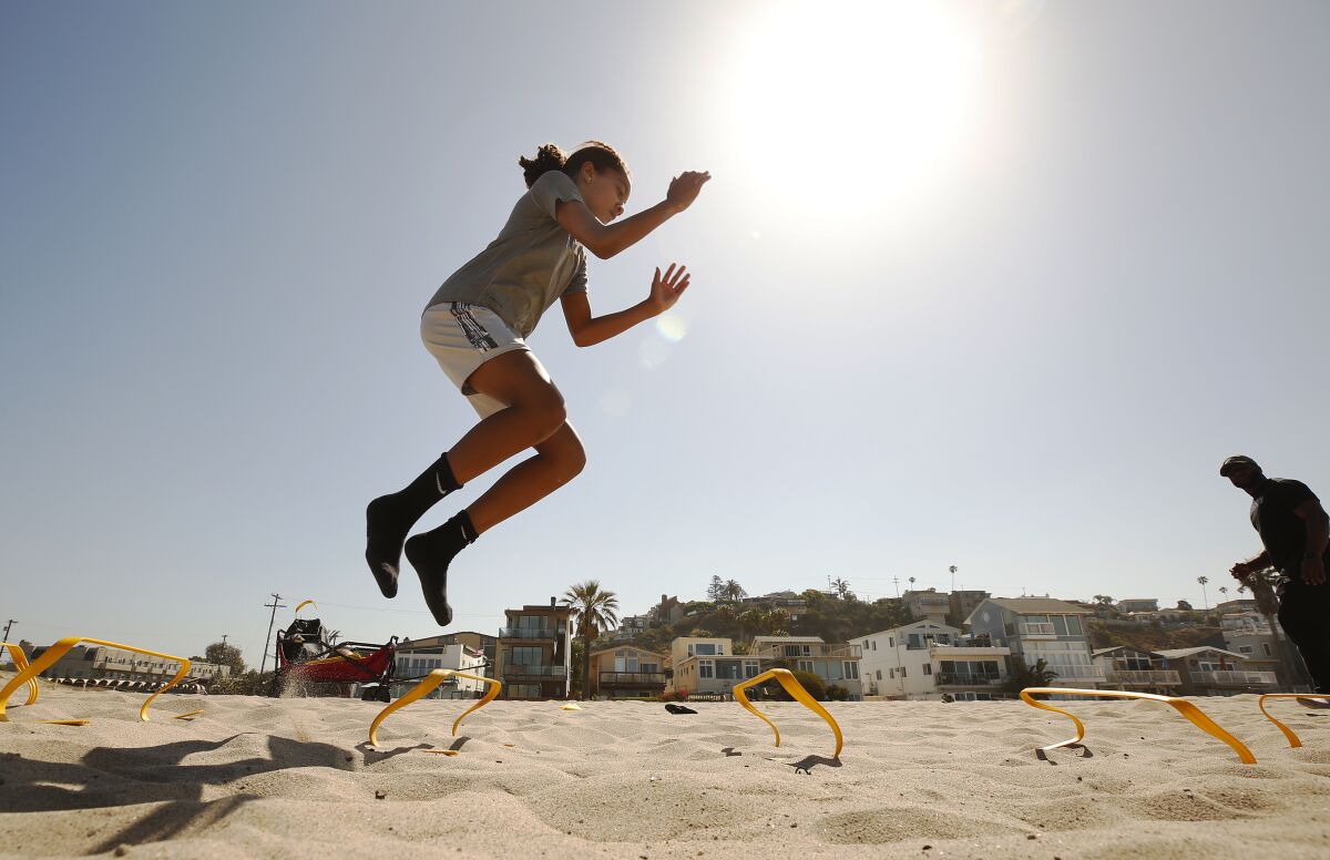 Taylor Scandrick, 11, goes airborne during a sand workout.