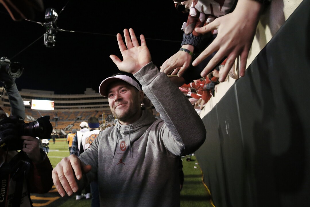 Oklahoma coach Lincoln Riley celebrates with fans following a game against Oklahoma State 