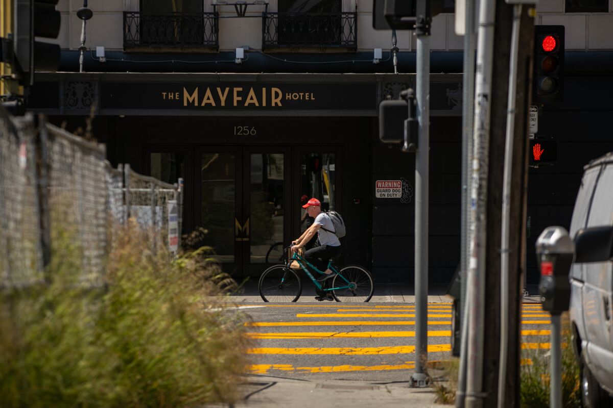 A bicyclist rides past the Mayfair Hotel, a 15-story hotel in L.A.'s Westlake neighborhood.