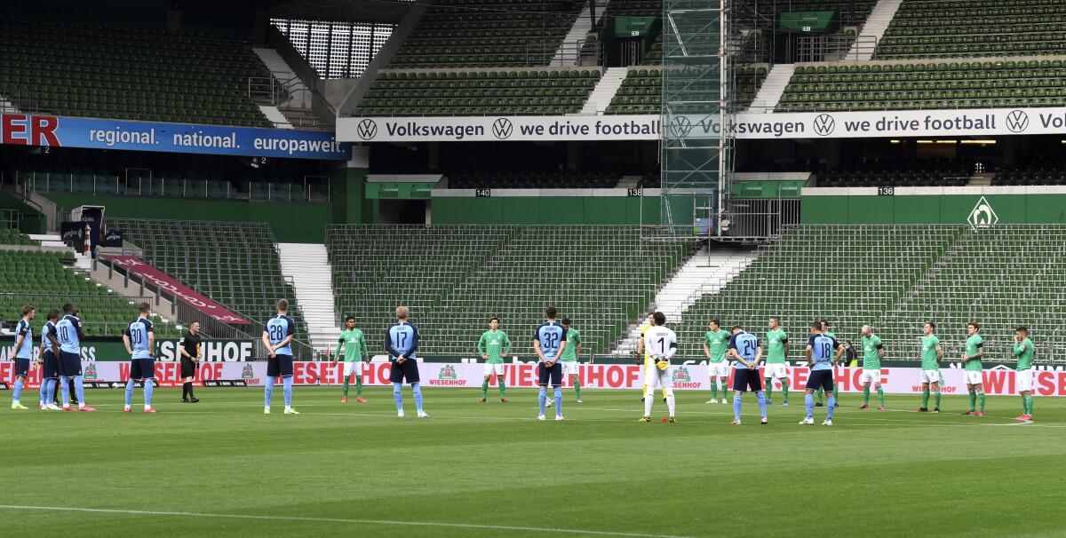 Players stand during a minute's silence for the victims of the coronavirus before a Bundesliga game between Werder Bremen and Borussia Moenchengladbach on May 26, 2020.
