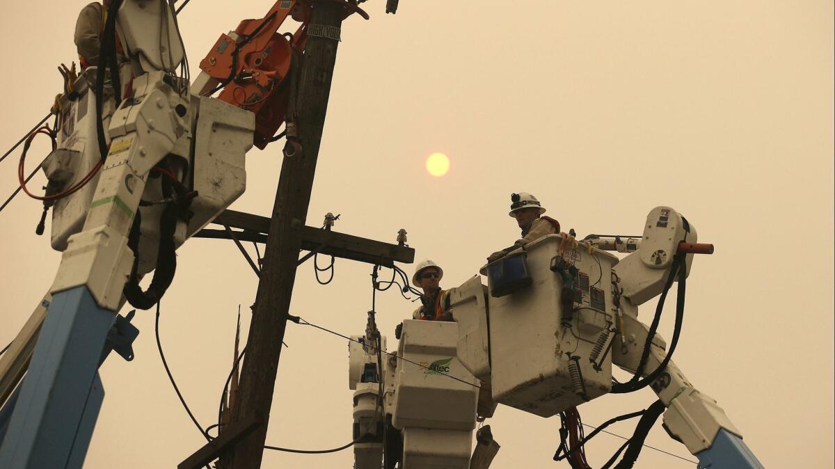 Pacific Gas & Electric crews work to restore power lines in Paradise, Calif., on Nov. 9.
