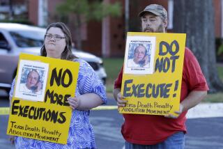 Jennifer Martin, left, and Thomas Roberson, older brother of condemned prisoner Robert Roberson, right, holds signs as they protest outside the prison where Roberson is scheduled for execution at the Huntsville Unit of the Texas State Penitentiary, Thursday, Oct. 17, 2024, in Huntsville, Texas. (AP Photo/Michael Wyke)