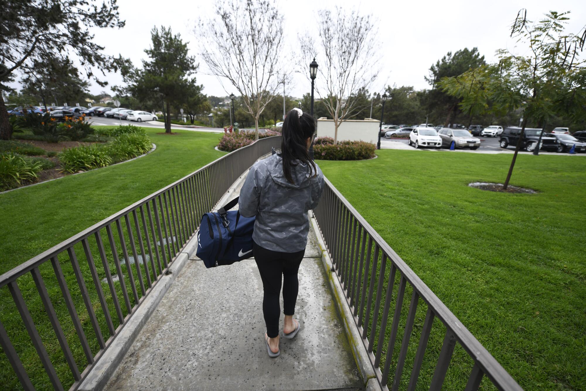 A student leaves University of San Diego dorms carrying a duffel bag