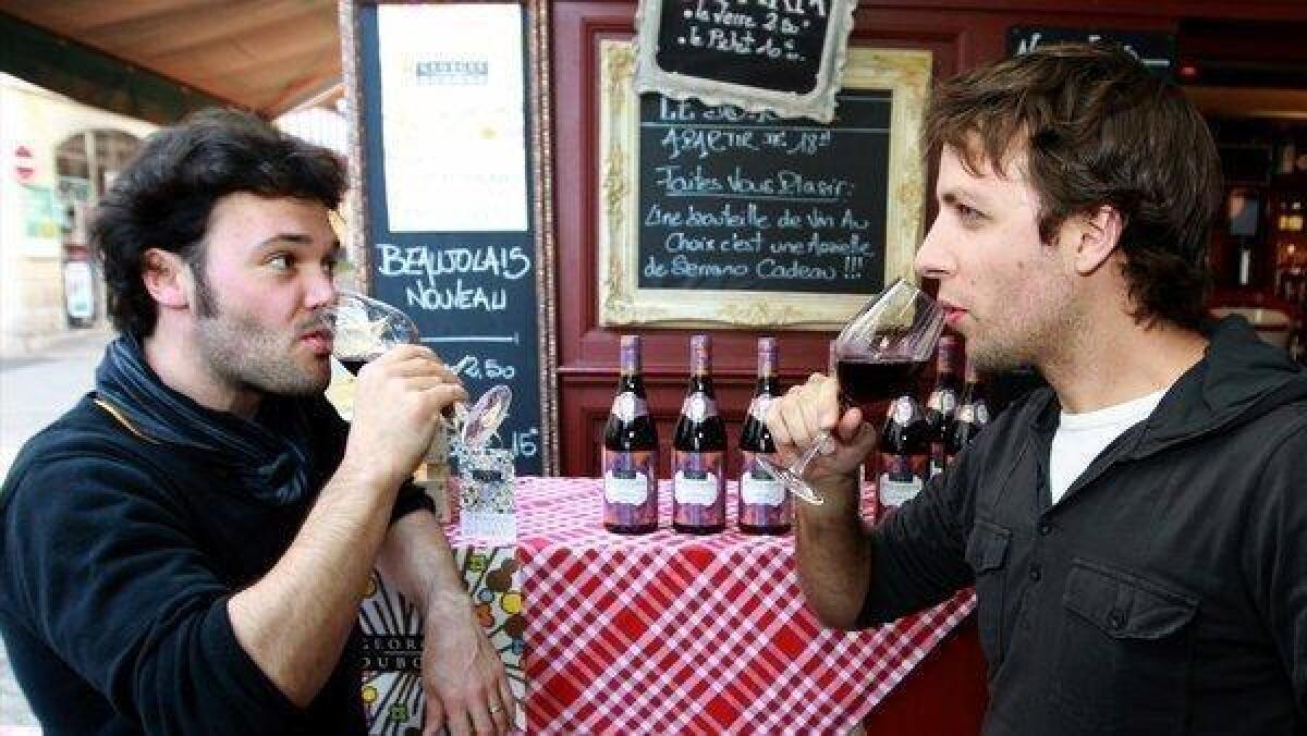 Customers at a wine shop in Bayonne, France, enjoy the first glasses of Beaujolais Nouveau.