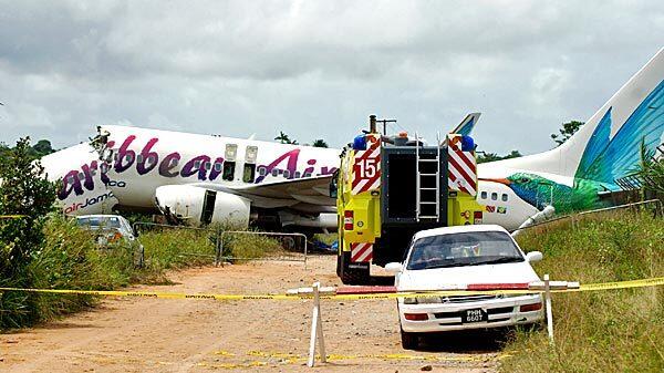 The broken fuselage of a Caribbean Airlines' Boeing 737-800 is seen after it crashed at the end of the runway at Cheddi Jagan International Airport in Timehri, Guyana, Saturday. The Caribbean Airlines flight 523 from New York touched down on the rainy runway, slid through a chain-link fence and broke apart just short of a ravine.