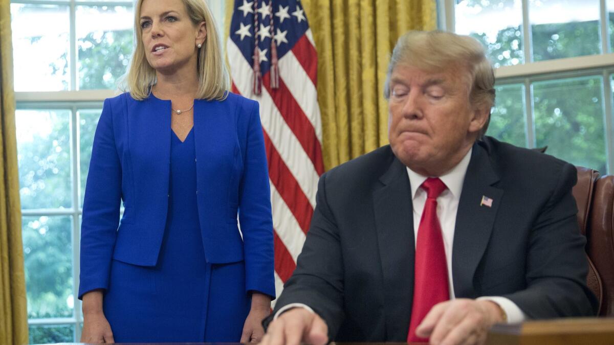 President Trump listens as Homeland Security Secretary Kirstjen Nielsen addresses members of the media before he signs an executive order to end family separations at the border.