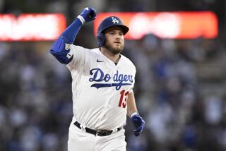 Los Angeles Dodgers' Max Muncy celebrates while rounding second base on a solo home run against the Cincinnati Reds.