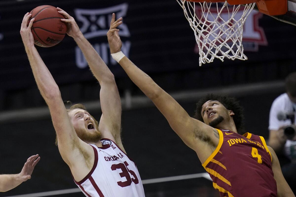 Oklahoma forward Brady Manek (35) goes up for a rebound next to Iowa State forward George Conditt IV (4) during the first half of an NCAA college basketball game in the first round of the Big 12 men's tournament in Kansas City, Mo., Wednesday, March 10, 2021. (AP Photo/Orlin Wagner)