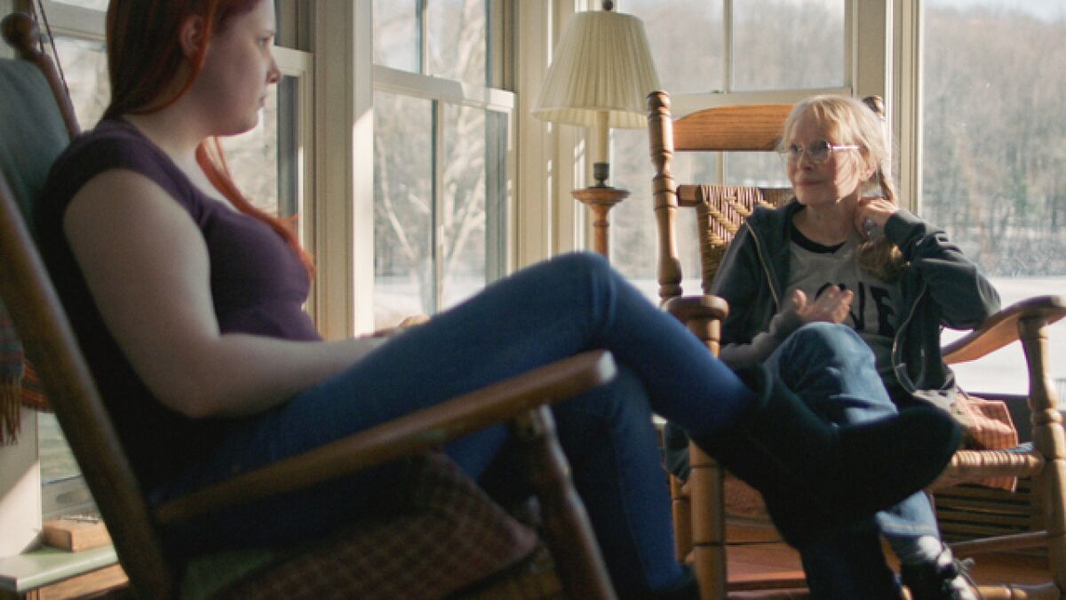 Two women sitting on an enclosed porch in winter