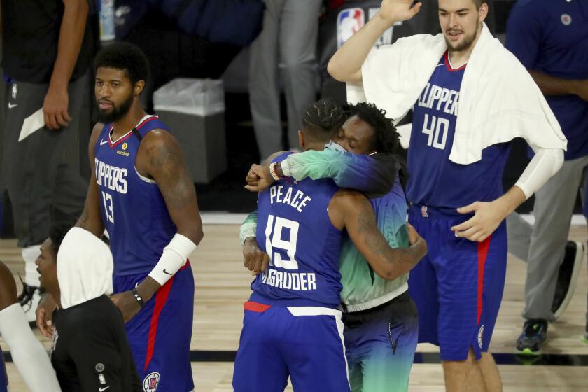 Rodney McGruder (19) is hugged by Clippers teammate Patric Beverley after making a key three-pointer Saturday.