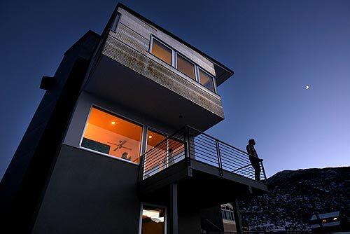 Tim Gallagher stands on the rear deck of his new home in Crowley Lake, a town about 15 minutes south of Mammoth Lakes. The house, designed by Tim's brother, Dan, is conceived as a series of stacked boxes sheathed in glass, cement board and corrugated metal that will require little maintenance. The result is a constructivist homage to the craggy peaks of Mammoth — and a departure from the traditional wood cabins that have long defined residential architecture in this region. Three bedrooms lie on the top floor, which cantilevers over the second floor and its public spaces: living room, kitchen and dining area. The bottom floor includes a rental apartment.