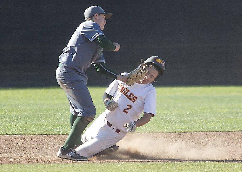 Costa Mesa High's Cameron Chapman tags out Estancia's Austin Reyes on the head.