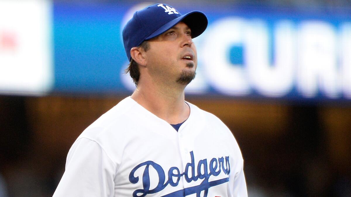 Dodgers starter Josh Beckett reacts to his throwing error to first base during the first inning of the team's 10-3 loss to the Cleveland Indians at Dodger Stadium on Tuesday.