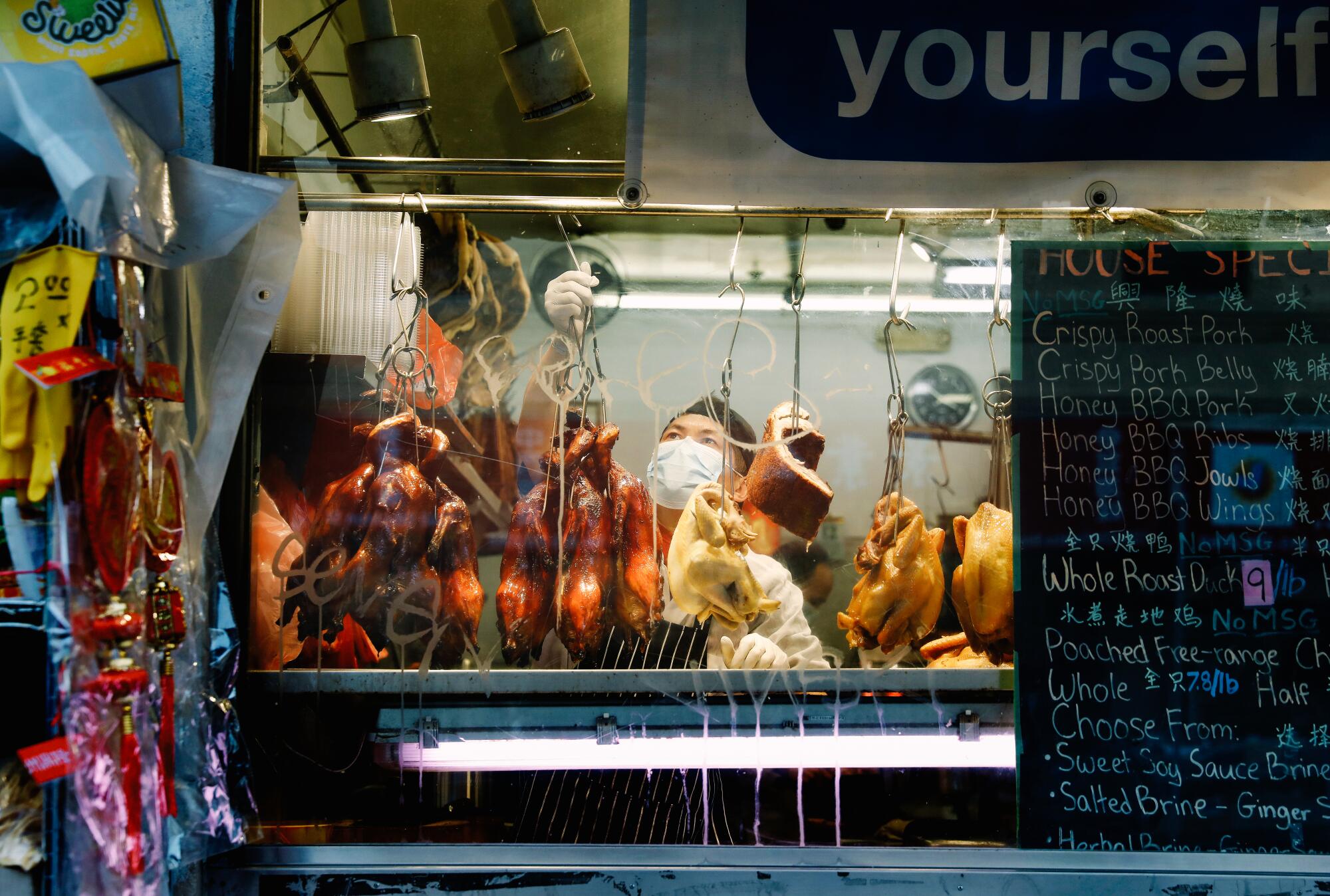 Poultry hangs from hooks.