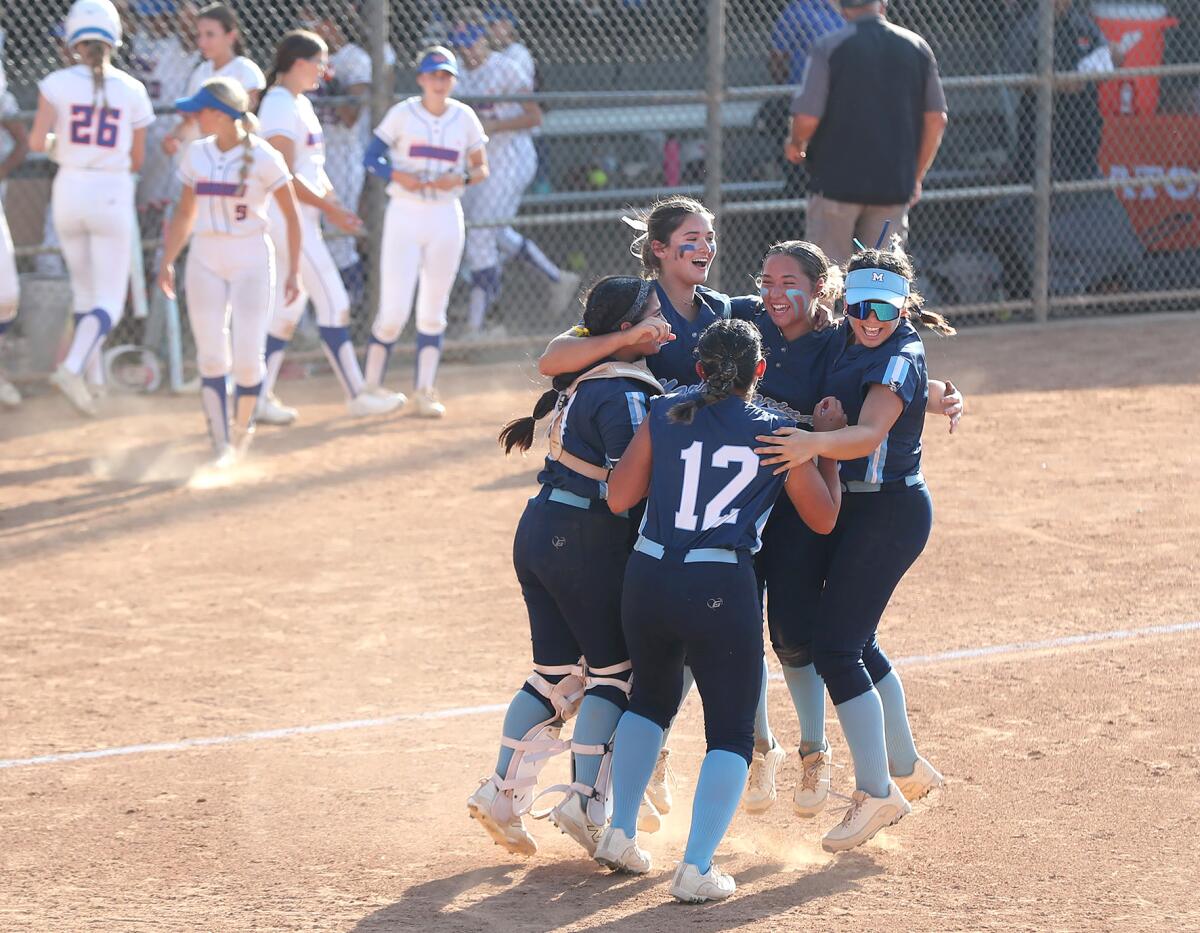 Members of the Marina infield celebrate winning the CIF Southern Section Division 3 softball final against Westlake.