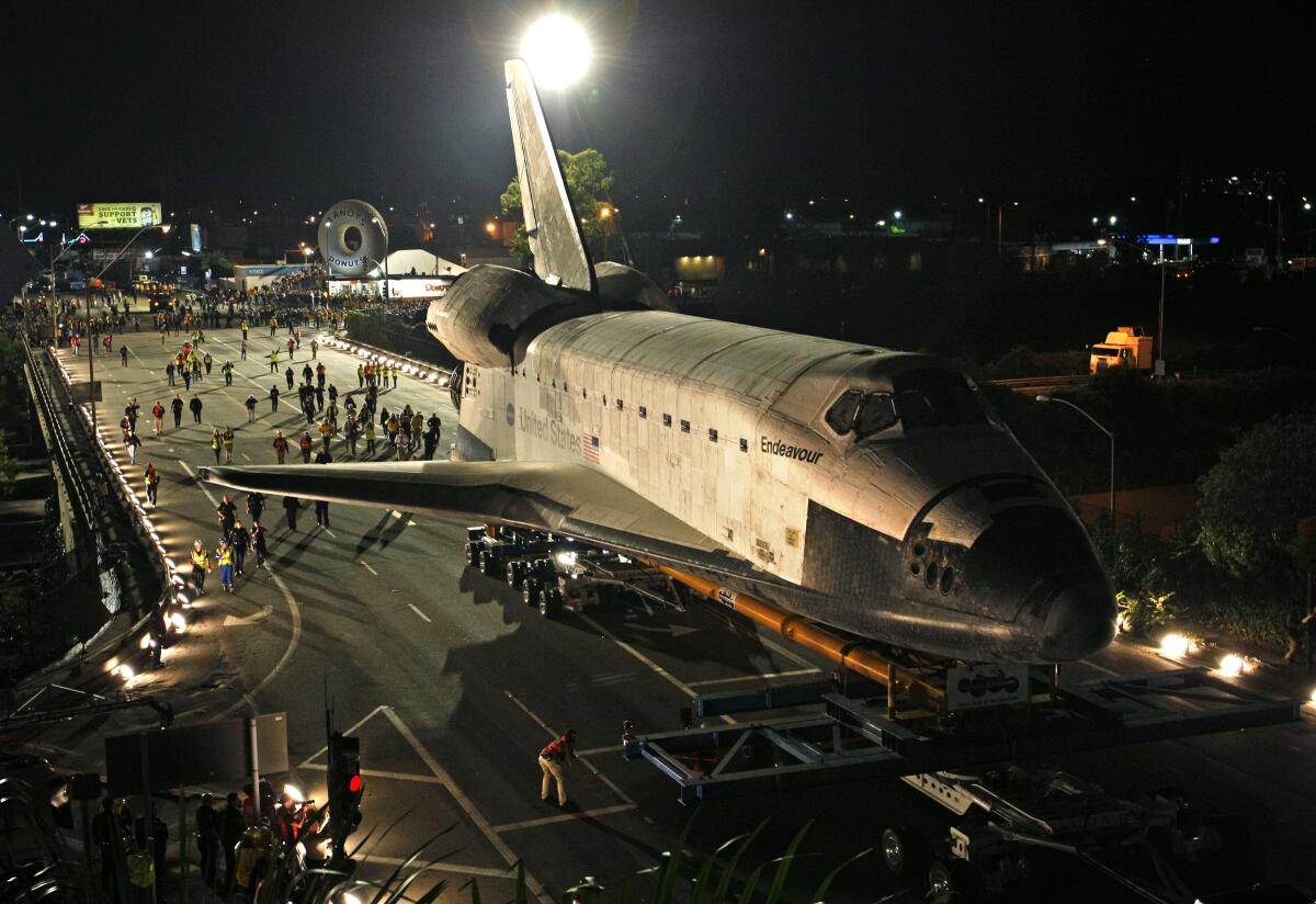 The space shuttle Endeavor is towed along L.A. streets at night