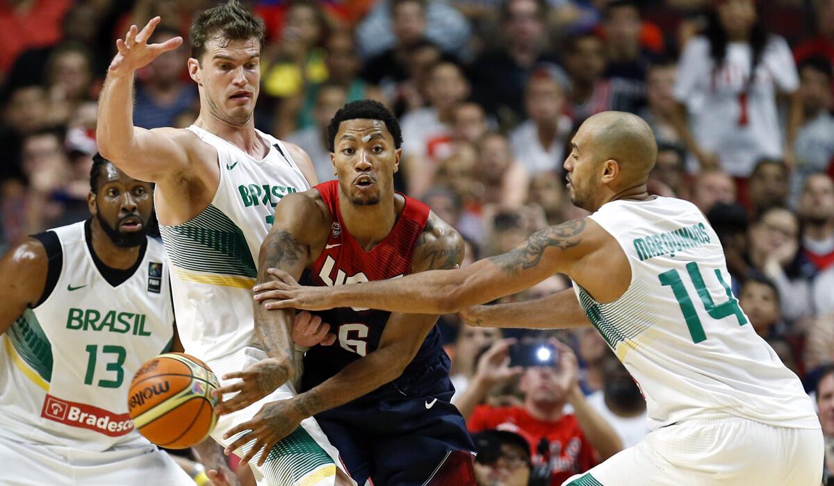Derrick Rose passes the ball past Brazil's Marcus Vinicius de Souza, right, and Tiago Splitter, second left, while center Nene looks on Saturday night at the United Center in Chicago.