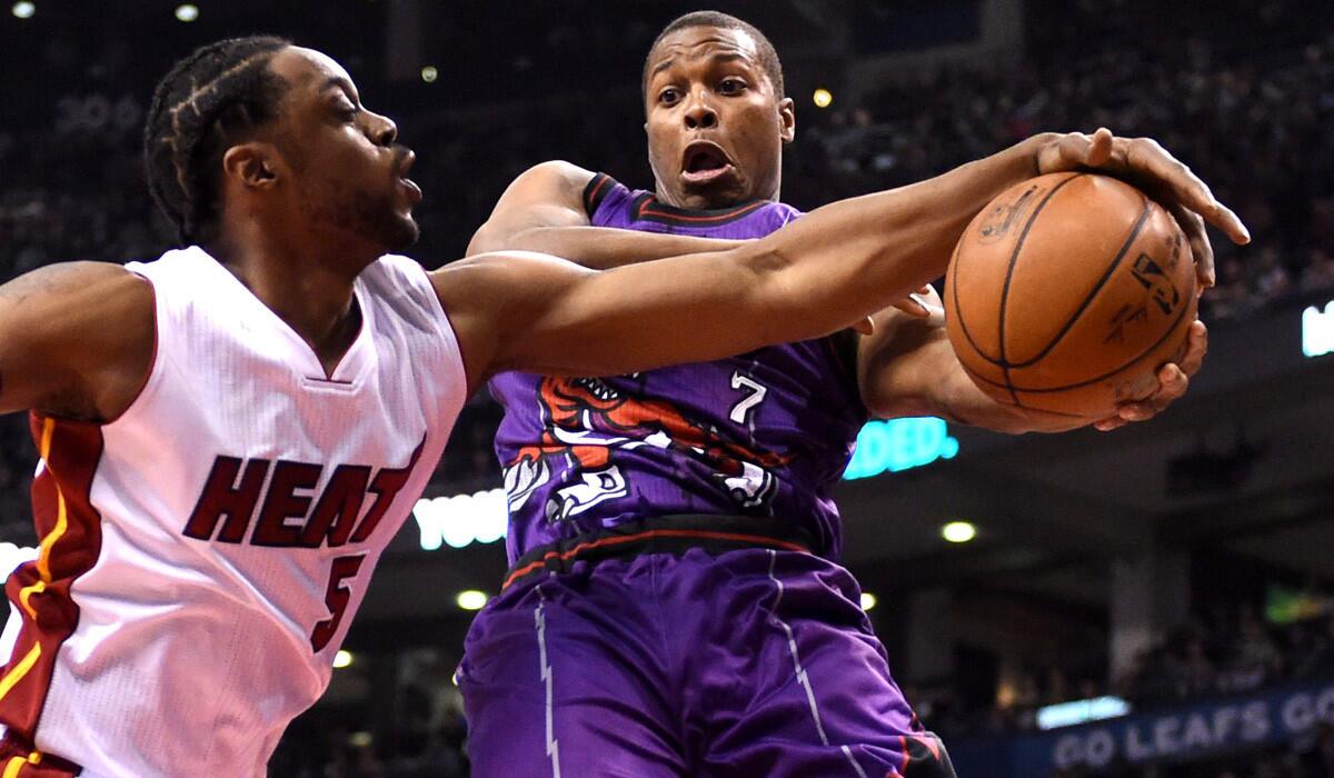 Toronto's Kyle Lowry, right, and Miami forward Henry Walker battle for the ball during the Raptors' 102-92 win over the Heat on Friday.