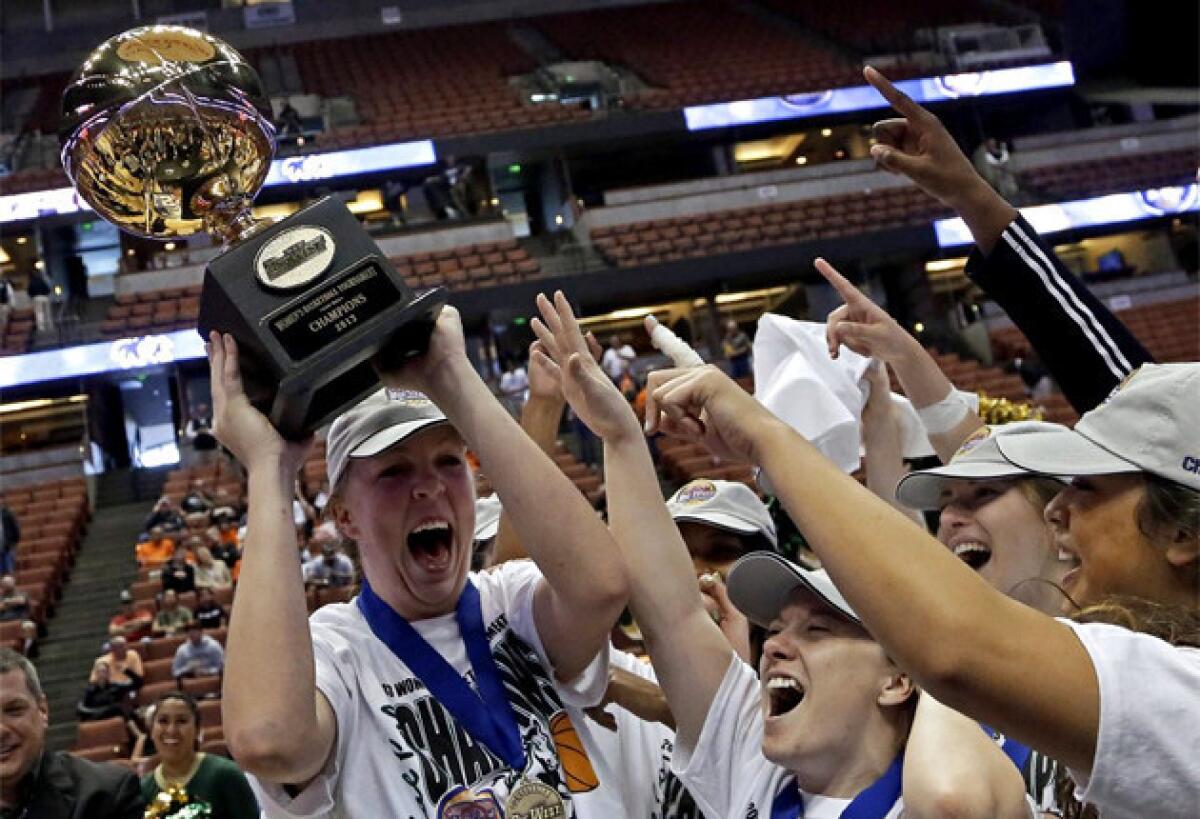 Molly Schlemer holds the trophy as she and teammates celebrate their 63-49 win over Pacific.