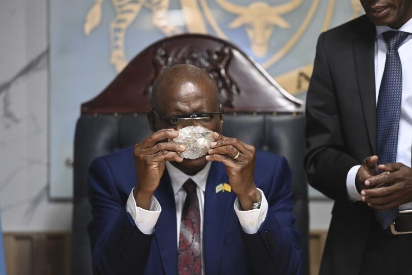 Botswana's President Mokgweetsi Masisi holds the 2,492-carat diamond that was unearthed at one of its mines and will be put on show, Thursday, Aug. 22, 2024, in Gaborone. (AP Photo)