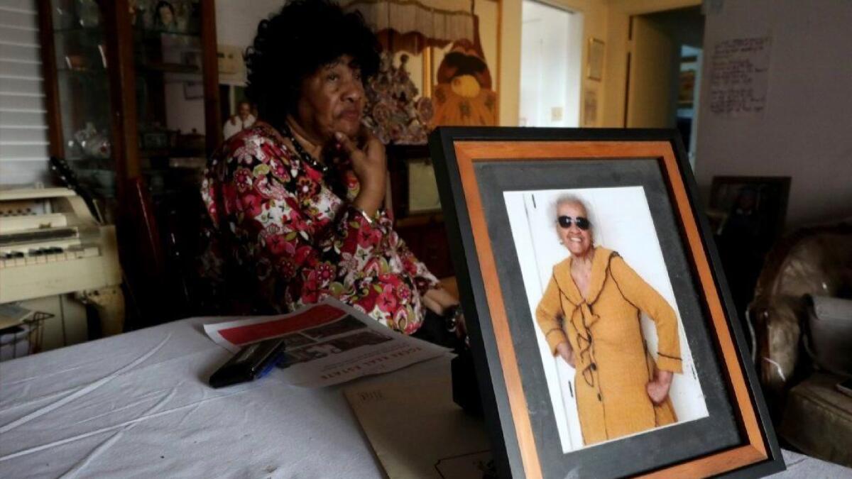 Pauline Cooper is seen with a photo of her 102-year-old neighbor, Thelma Smith, who has received a 90-day notice of eviction.