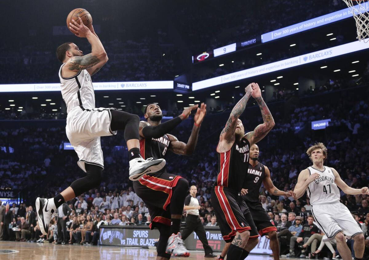 Brooklyn guard Deron Williams goes up to shoot against Miami's LeBron James and Chris Andersen on Saturday night in New York.