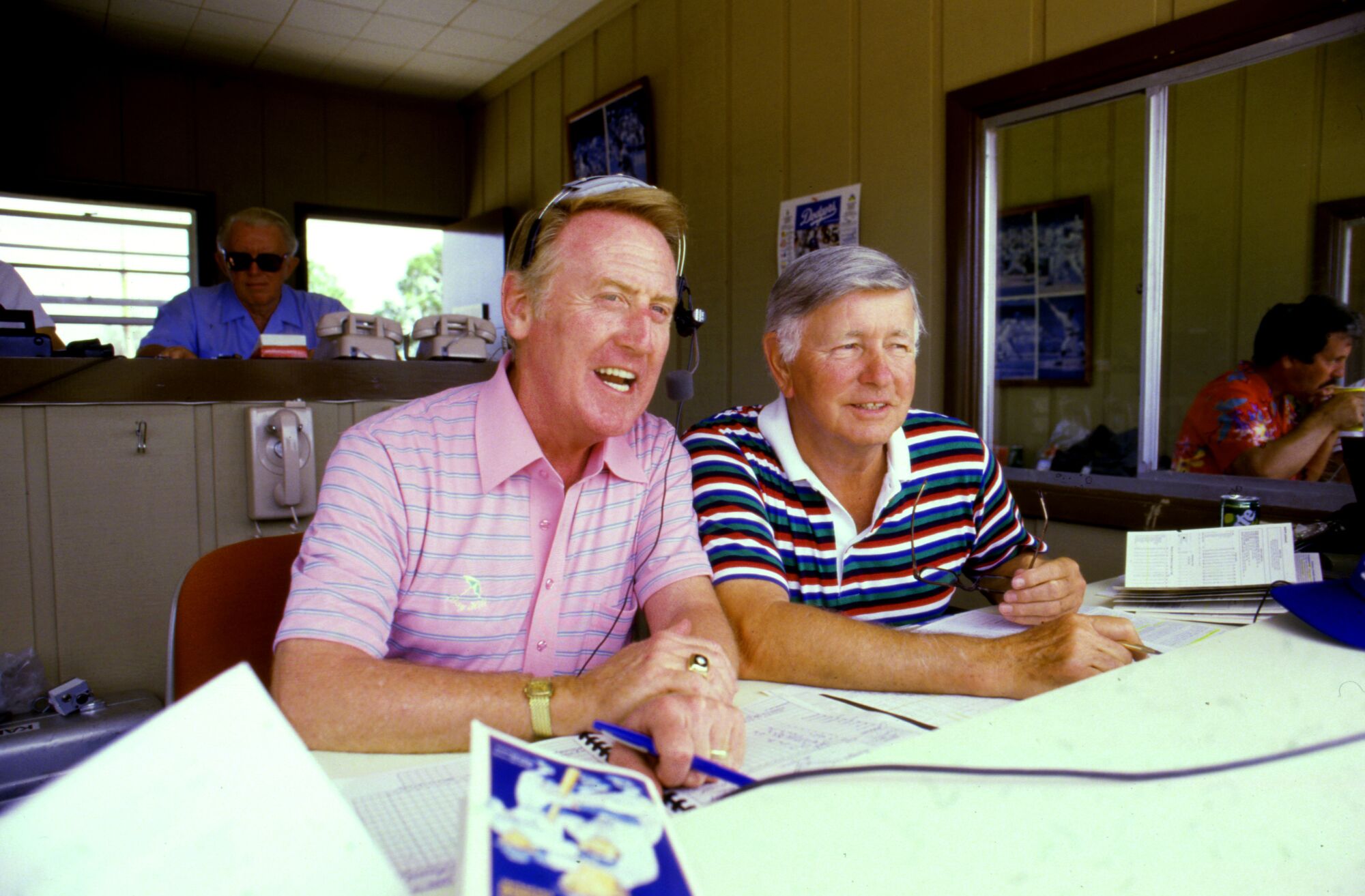 Dodgers broadcaster Vin Scully, left, and Jerry Doggett work in the announcer's booth during a spring training game.