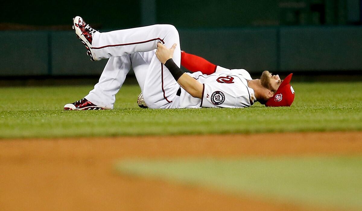 Washington Nationals' Bryce Harper grabs his hamstring on the field after being injured in the sixth inning against the Tampa Bay Rays on Thursday.