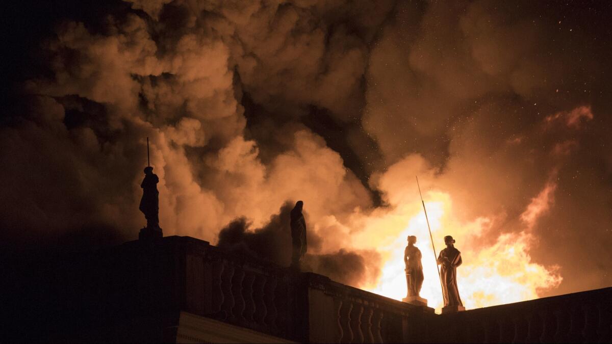 A massive fire illuminates statues as it tears through the roof of the National Museum of Brazil in Rio de Janeiro on Sept. 2.