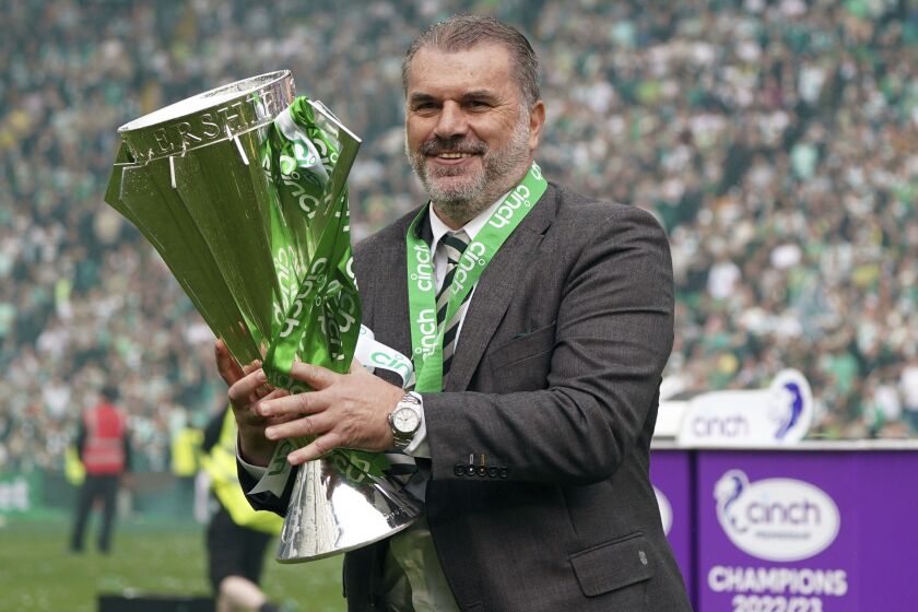 Celtic manager Angelos Postecoglou celebrates with the league trophy after winning the Scottish Premiership, at Celtic Park, Glasgow, Scotland, Saturday, May 27, 2023. (Andrew Milligan/PA via AP)