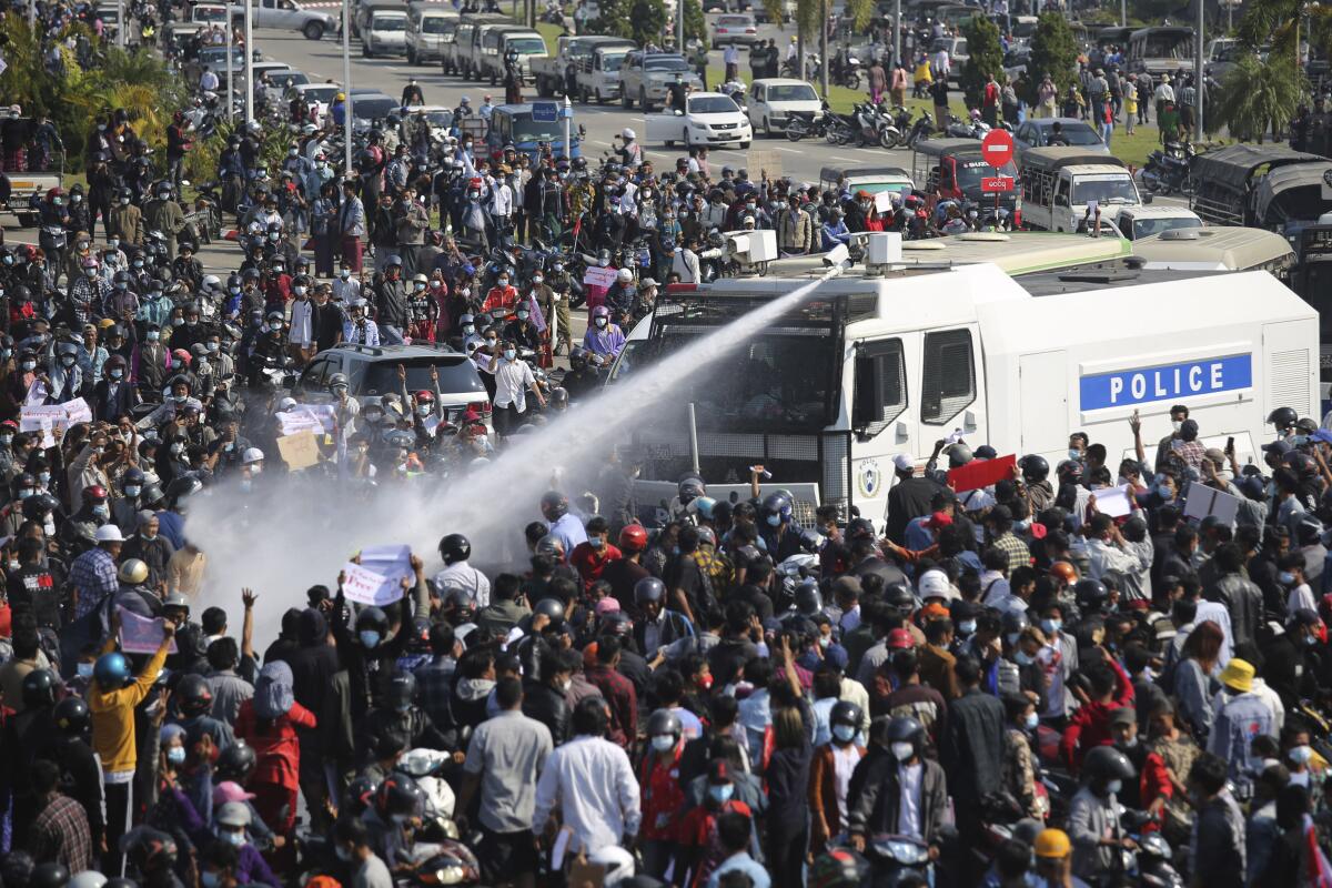 A police truck sprays water to a crowd of protesters in Naypyitaw, Myanmar