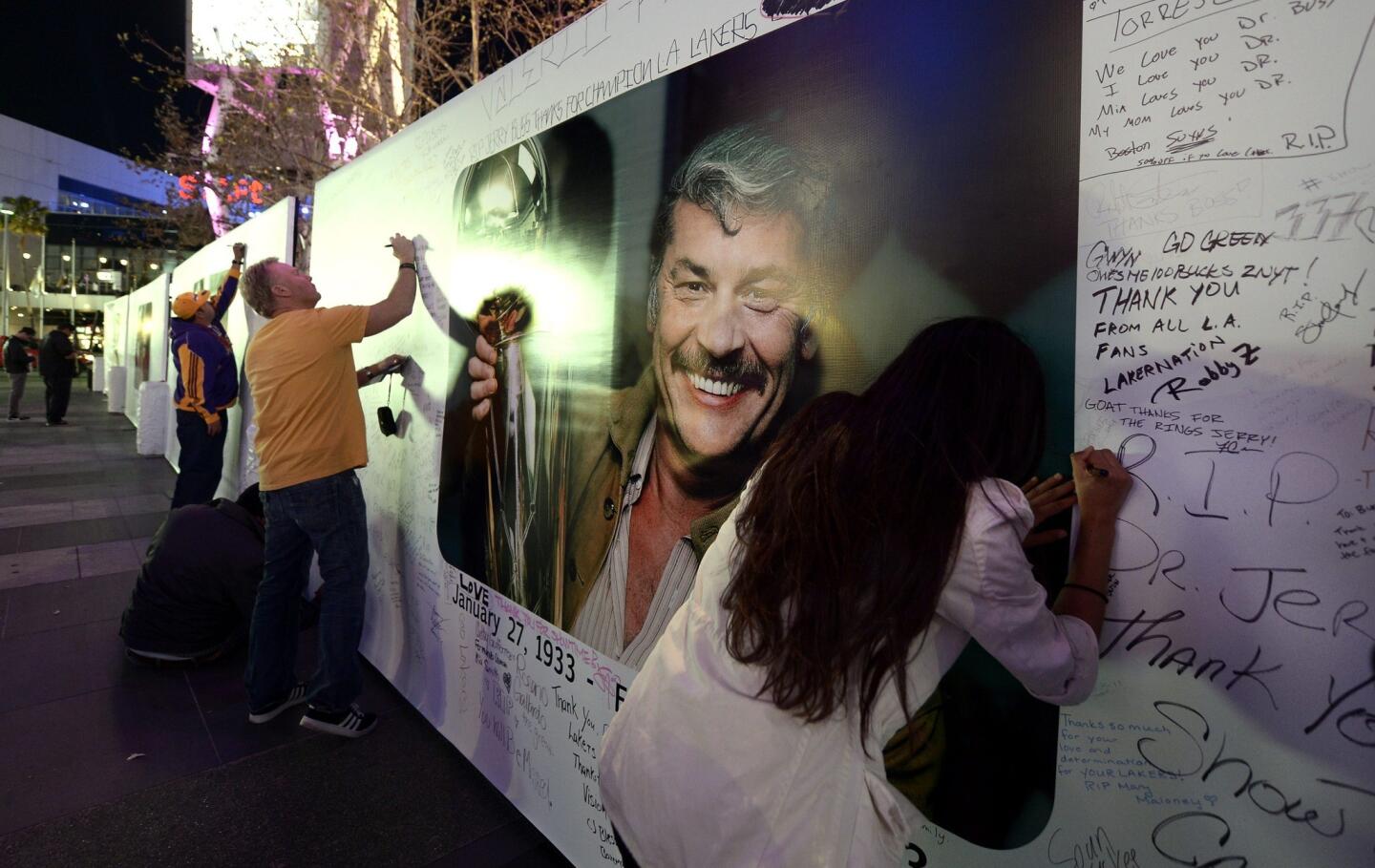 Fans sign a poster in honor of Lakers owner Jerry Buss, who died Monday at age 80, outside of Staples Center before a game against the Celtics on Wednesday night.