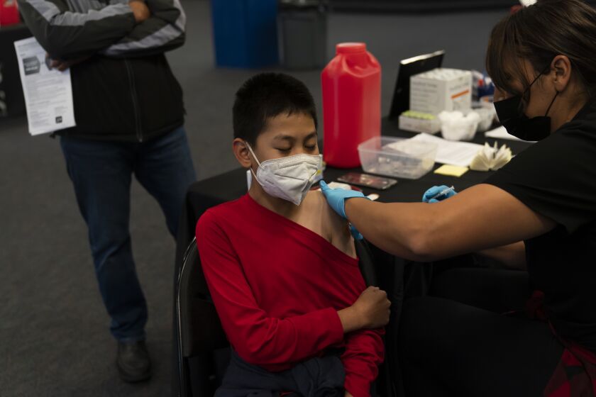 Johnny Thai, 11, receives the Pfizer COVID-19 vaccine at a pediatric vaccine clinic for children ages 5 to 11 set up at Willard Intermediate School in Santa Ana, Calif., Tuesday, Nov. 9, 2021. Health systems have released little data on the racial breakdown of youth vaccinations, and community leaders fear that Black and Latino kids are falling behind. (AP Photo/Jae C. Hong)