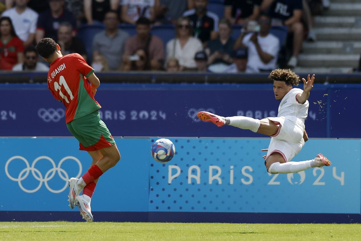 U.S. midfielder Kevin Paredes, right, shoots in front of Morocco's Zakaria El Ouahdi at the Paris Olympics.