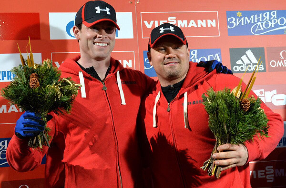 Steven Holcomb, left, and Steven Langton on the victory stand after winning the two-men bobsled race at a World Cup event in Austria on Saturday.