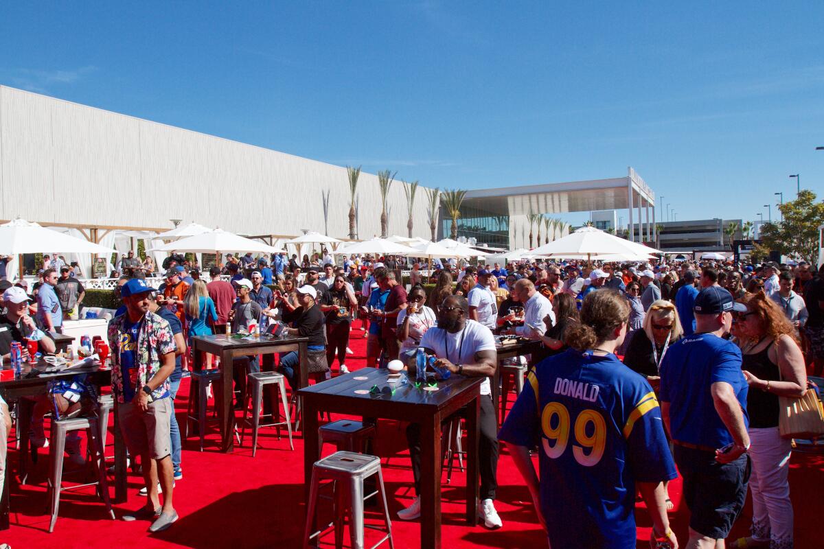 A wide shot of a crowd of people sitting and standing at the Players Tailgate outside of Inglewood's Hollywood Park Casino.