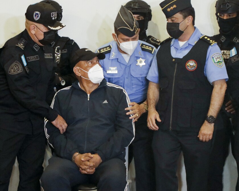 The former head of Honduras' national police Juan Carlos Bonilla Valladares, also known as the Tiger, or "El Tigre," in chains, is shown to the press in Tegucigalpa, Honduras, Wednesday, March 9, 2022. Bonilla Valladares, who was sought by U.S. prosecutors on drug and weapons charges, was arrested Wednesday according to a high-ranking police official. (AP Photo/Elmer Martinez)