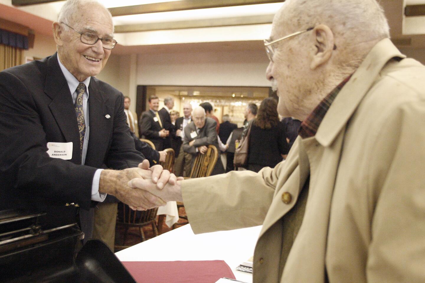Co-owner of Anderson Business Technologies Don Anderson, left, shakes Bob Hemmings' hand during his 100th anniversary celebration, which took placeat the University Club of Pasadena on Thursday, October 11, 2012.