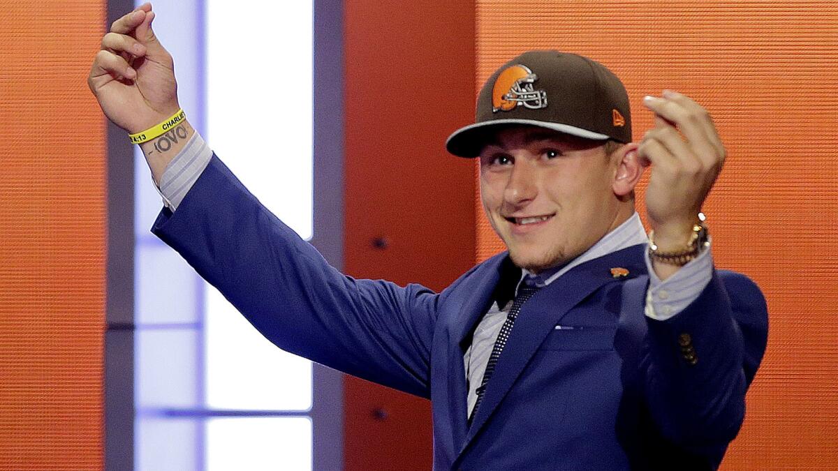 Heisman Trophy winner Johnny Manziel strikes his "money" pose after getting selected by the Cleveland Browns in the first round of the 2014 NFL draft.