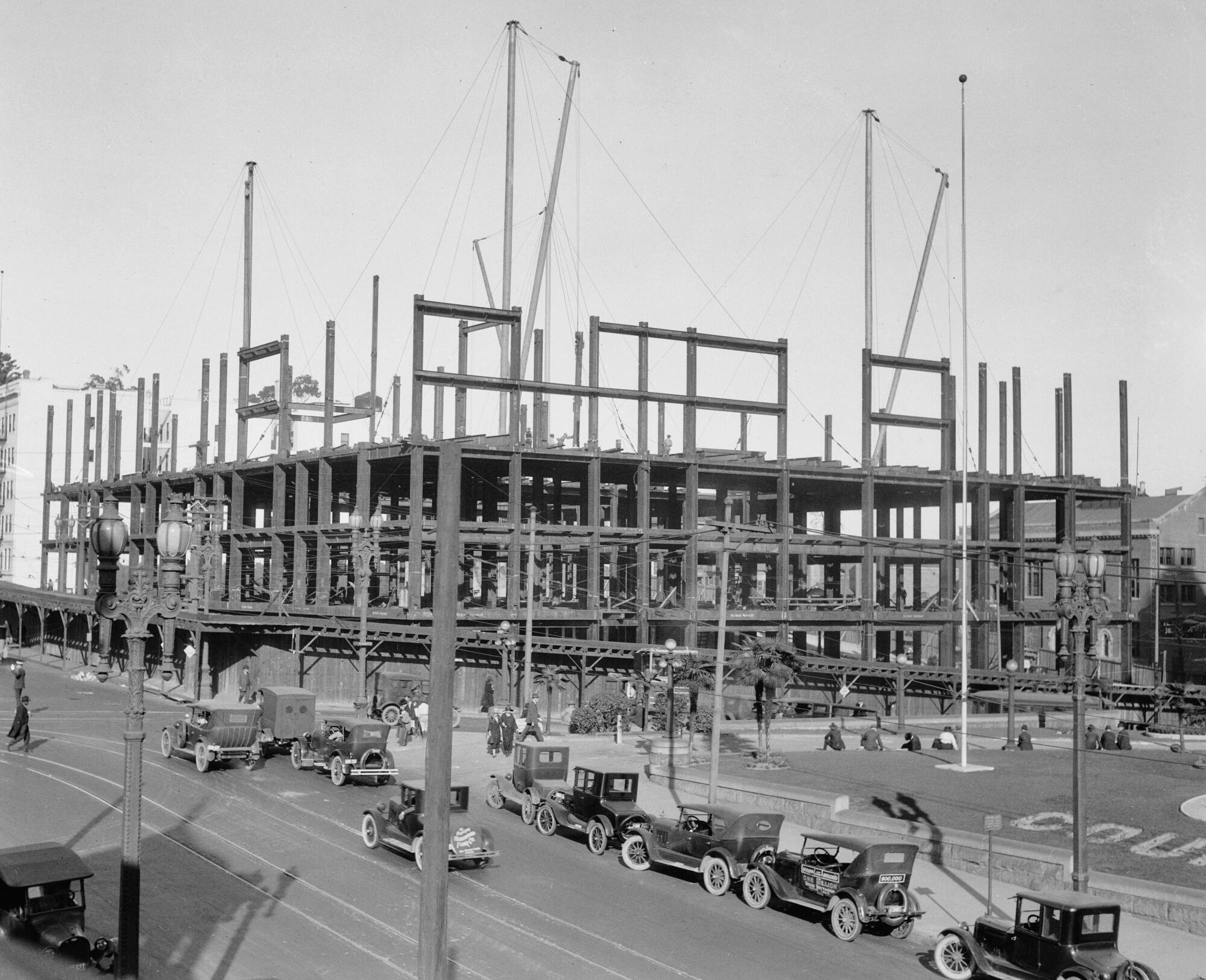 The frame of a huge structure next to a street.