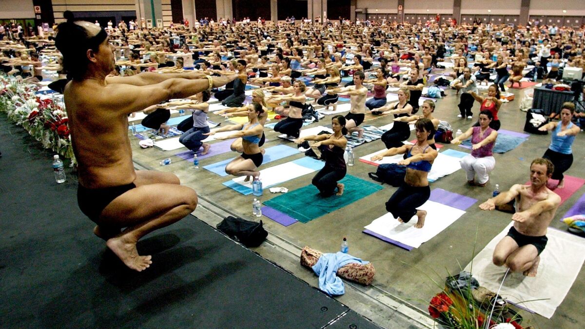 Bikram Choudhury, front, leads a class at the Yoga Expo at the Los Angeles Convention Center in 2003. On Wednesday, a judge issued an arrest warrant for him for failing to settle a judgment against him.