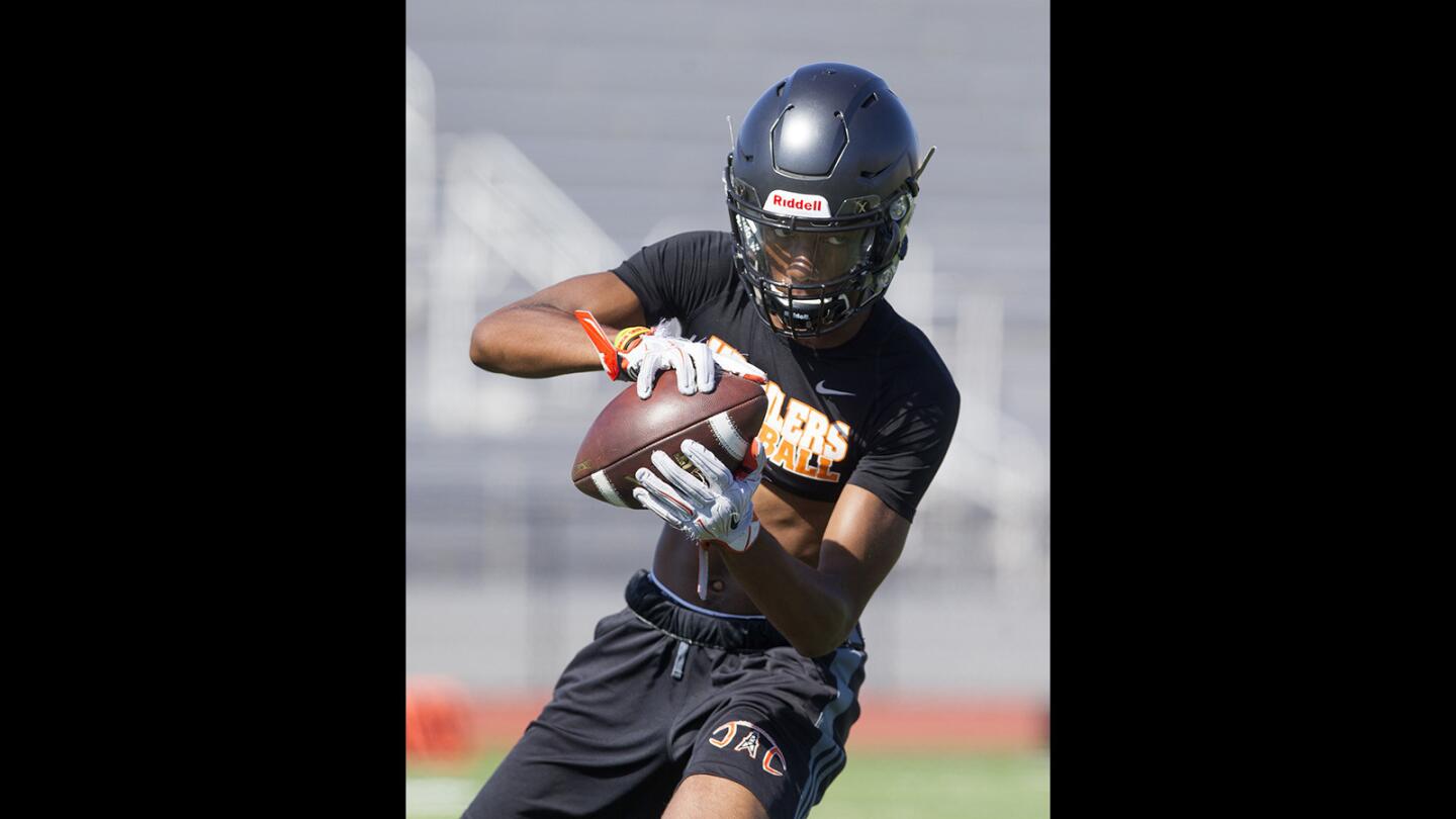 Huntington Beach High's Jerimiah Flanagan completes a pass during practice on Thursday. (Kevin Chang/ Daily Pilot)