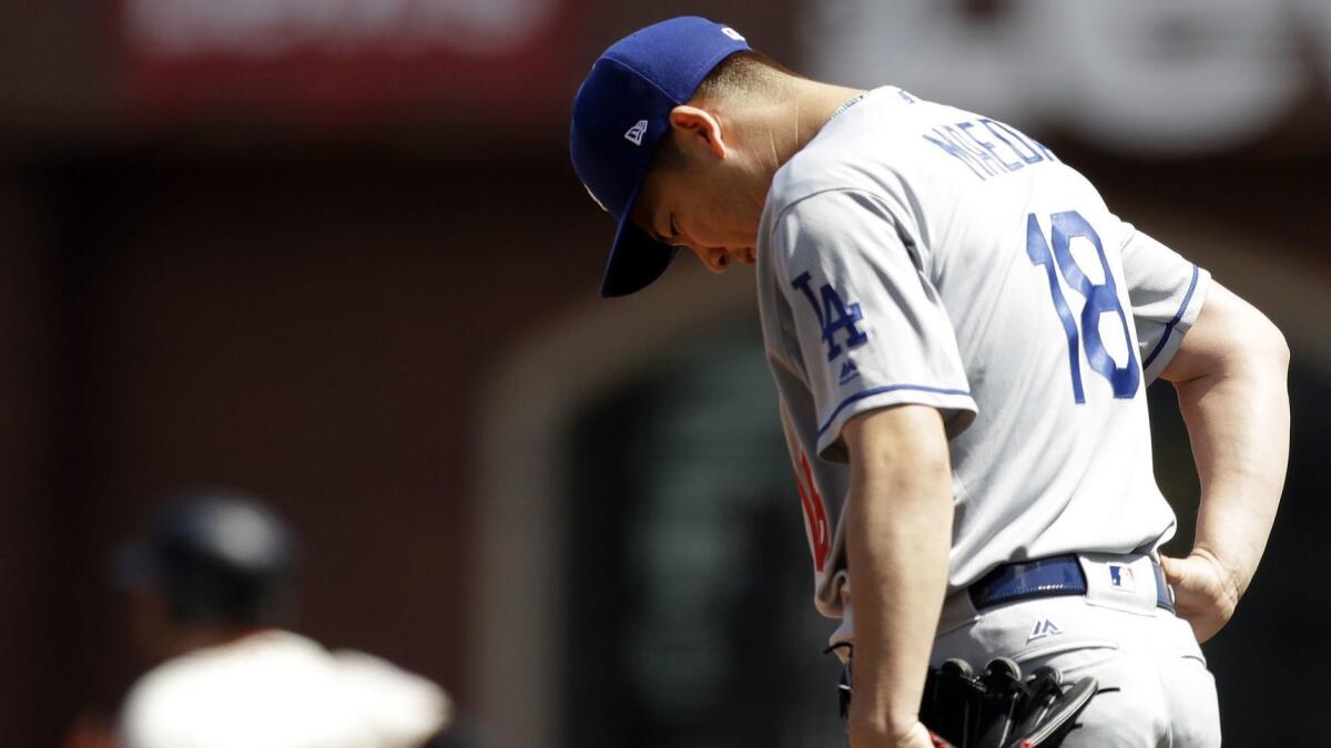 Dodgers starter Kenta Maeda lowers his head after giving up a three-run home run to the San Francisco Giants' Evan Longoria during the first inning.