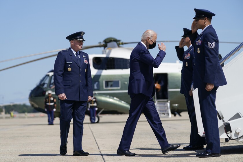 President Biden returns a salute as he walks to board Air Force One 