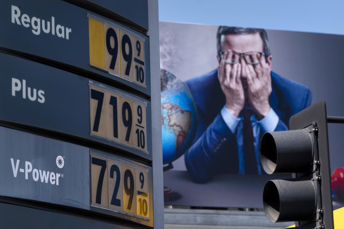 Los precios de la gasolina se ven frente a una valla publicitaria que anuncia Last Week Tonight 