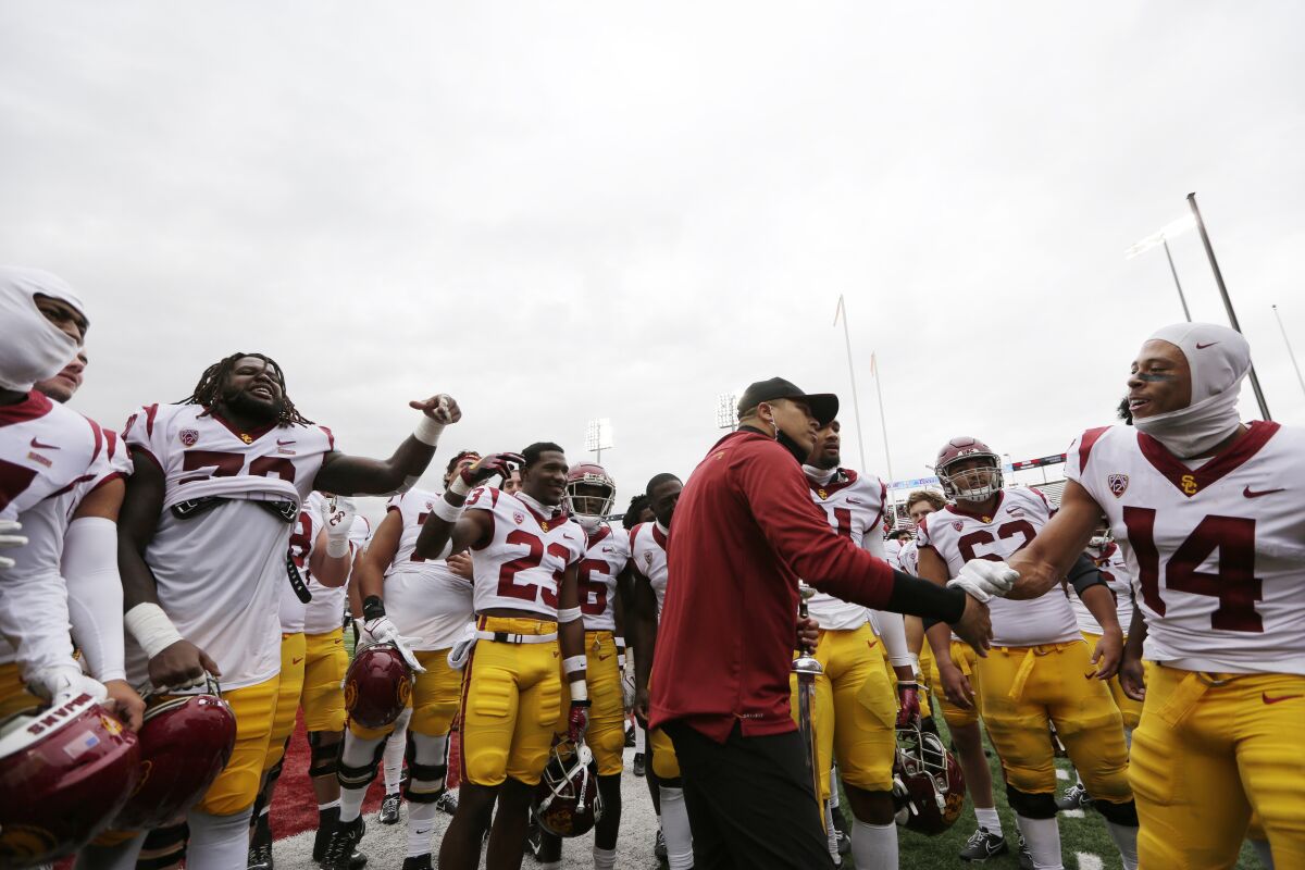 USC interim coach Donte Williams, center, celebrates with his team after a win over Washington State.